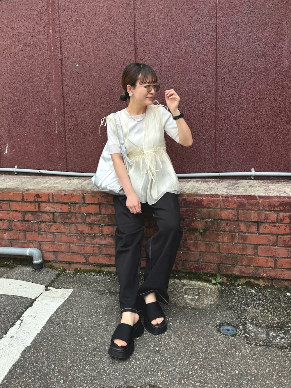 ホワイト系のニット/セーター、ブラック系のデニムパンツ、シルバー系のトートバッグを着用したレディースの夏コーディネートの3枚目の写真