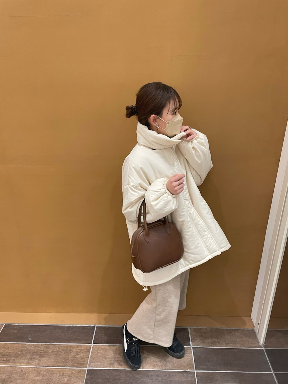 ホワイト系のブルゾン、ホワイト系のニット/セーター、ベージュ系のスカートを着用したレディースの冬コーディネートの4枚目の写真