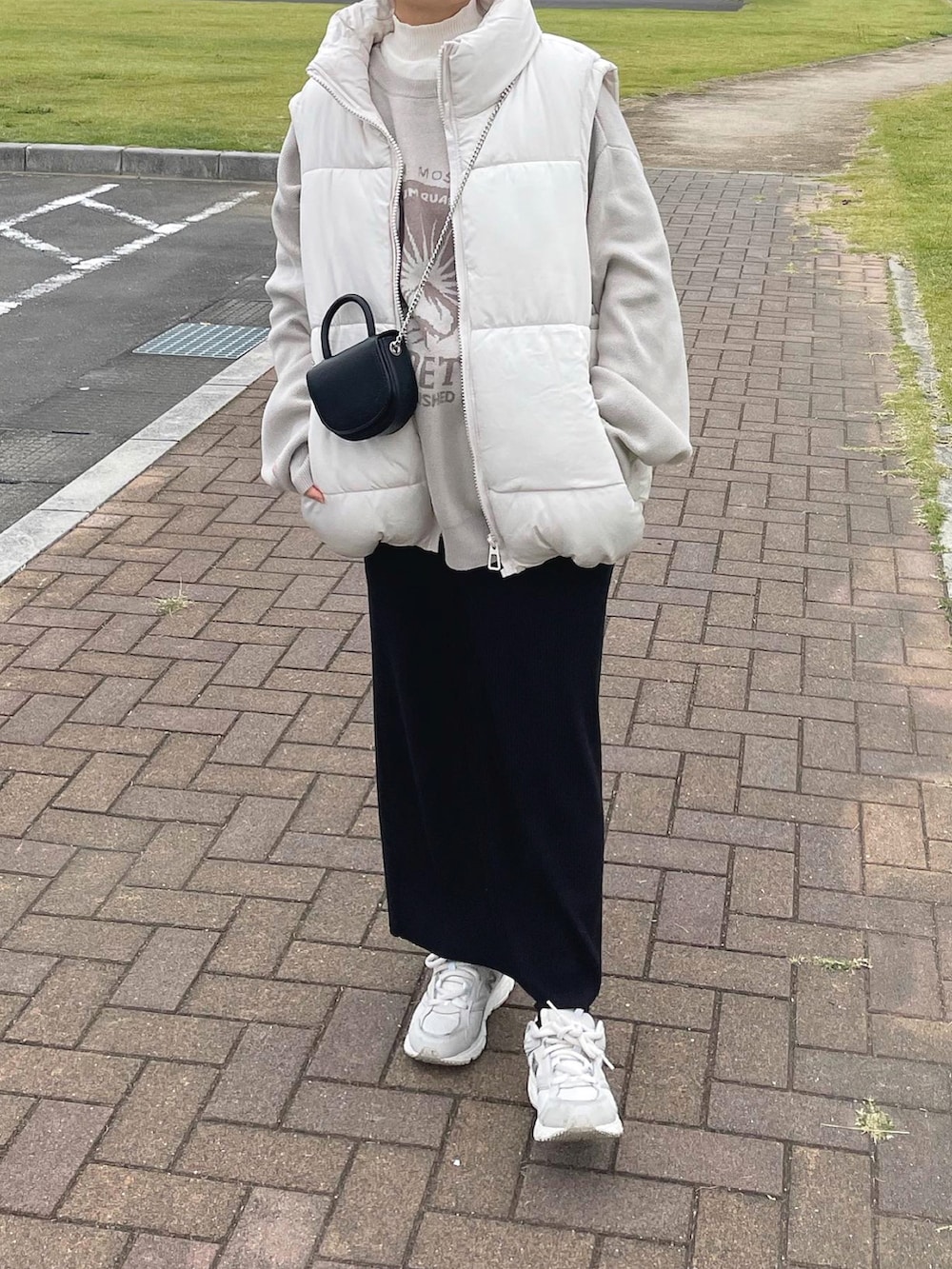 ベージュ系のニット/セーター、ホワイト系のニット/セーター、ブラック系のショルダーバッグを着用したレディースの冬コーディネートの4枚目の写真