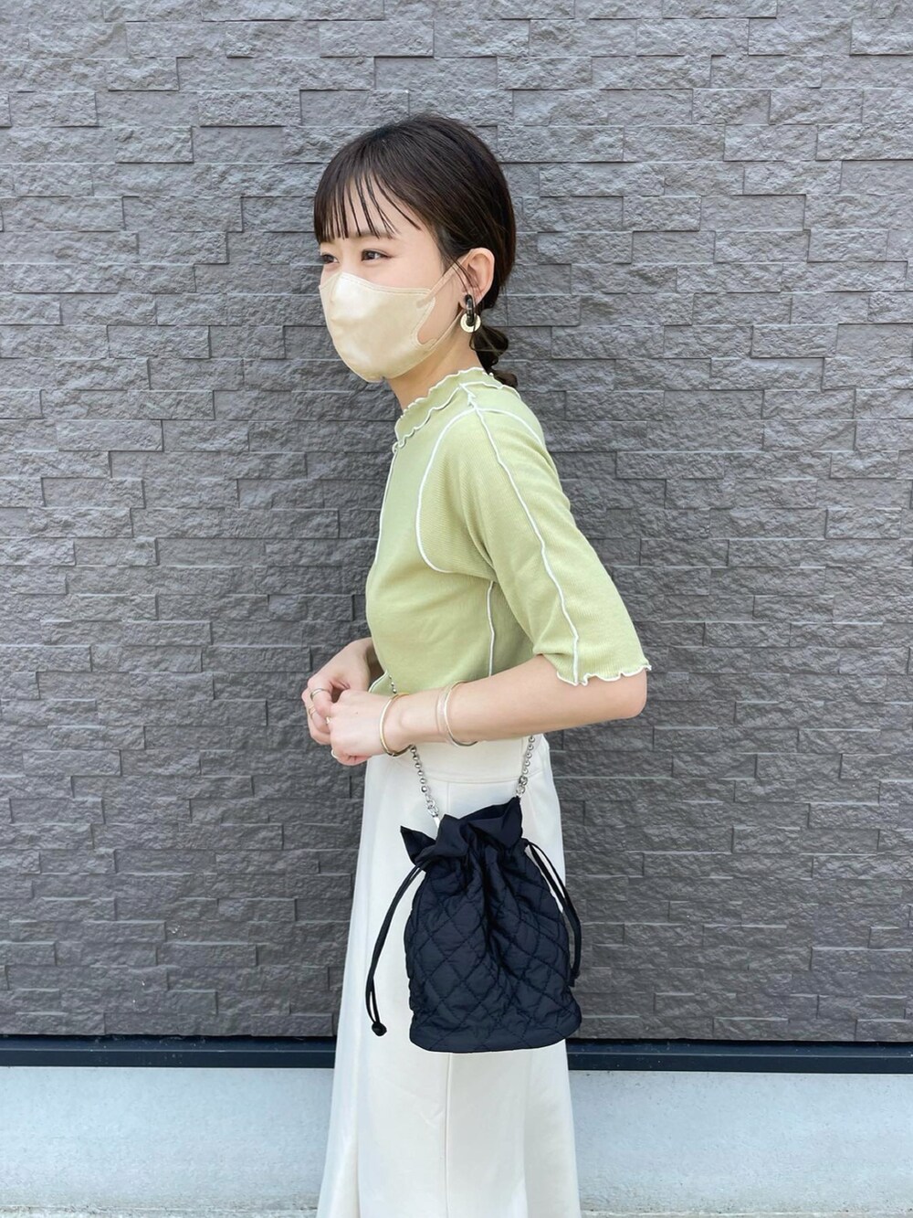 グリーン系のTシャツ/カットソー、ホワイト系のスカート、ブラック系のショルダーバッグを着用したレディースの夏コーディネートの4枚目の写真