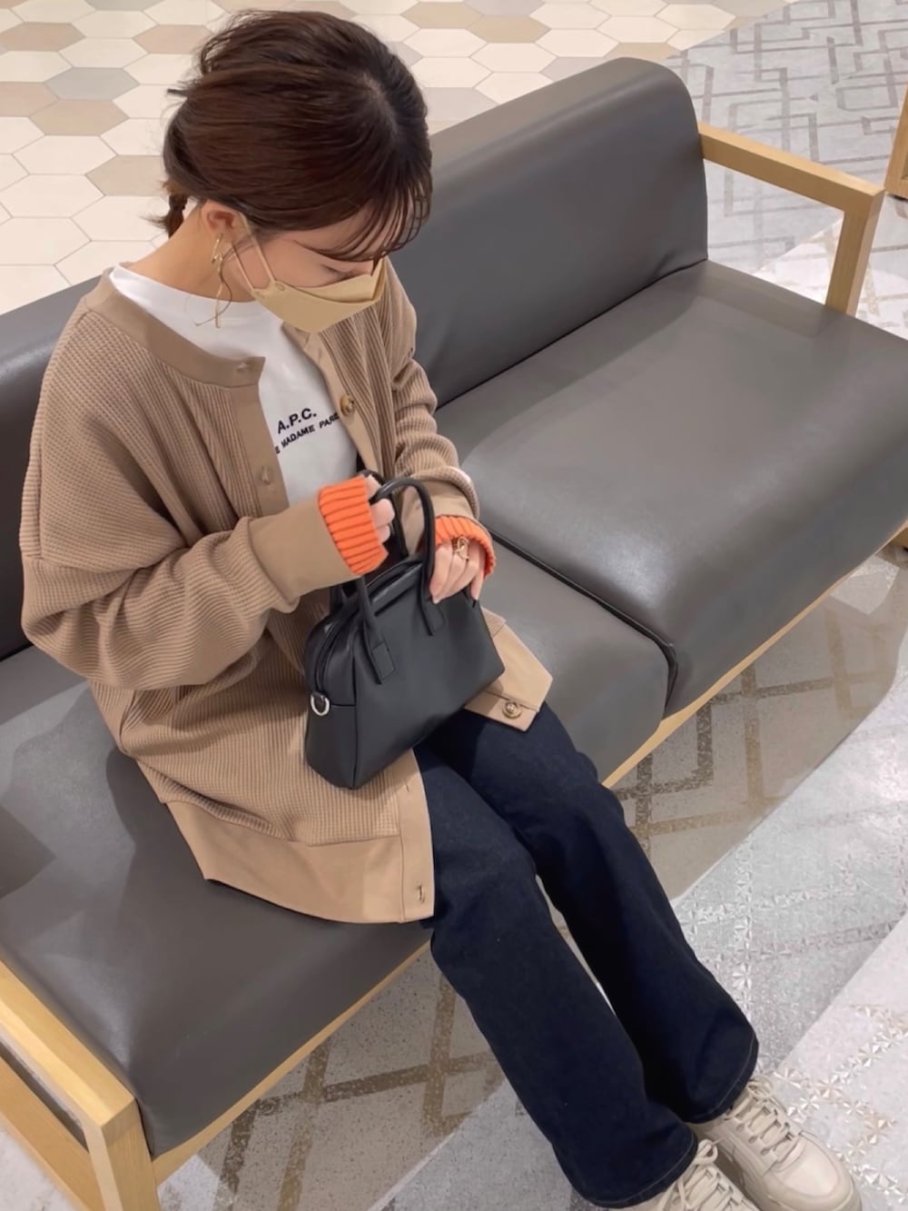 ブラウン系のカーディガン/ボレロ、ブルー系のデニムパンツ、ホワイト系のスニーカーを着用したレディースの春コーディネートの3枚目の写真