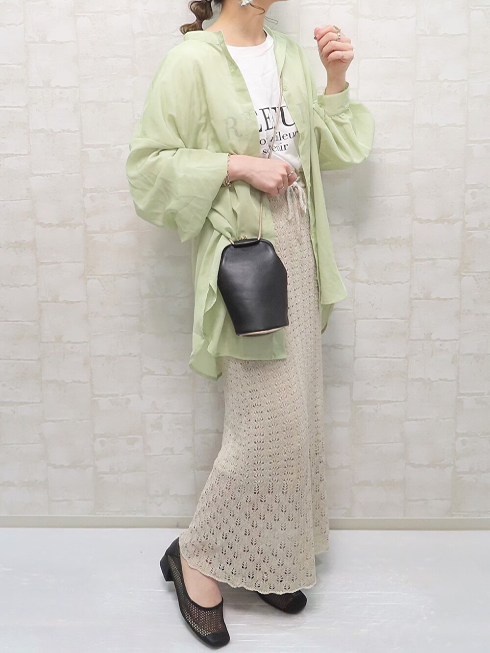 ベージュ系のスカート、ホワイト系のTシャツ/カットソー、ブラック系のパンプスを着用したレディースの春コーディネートの3枚目の写真