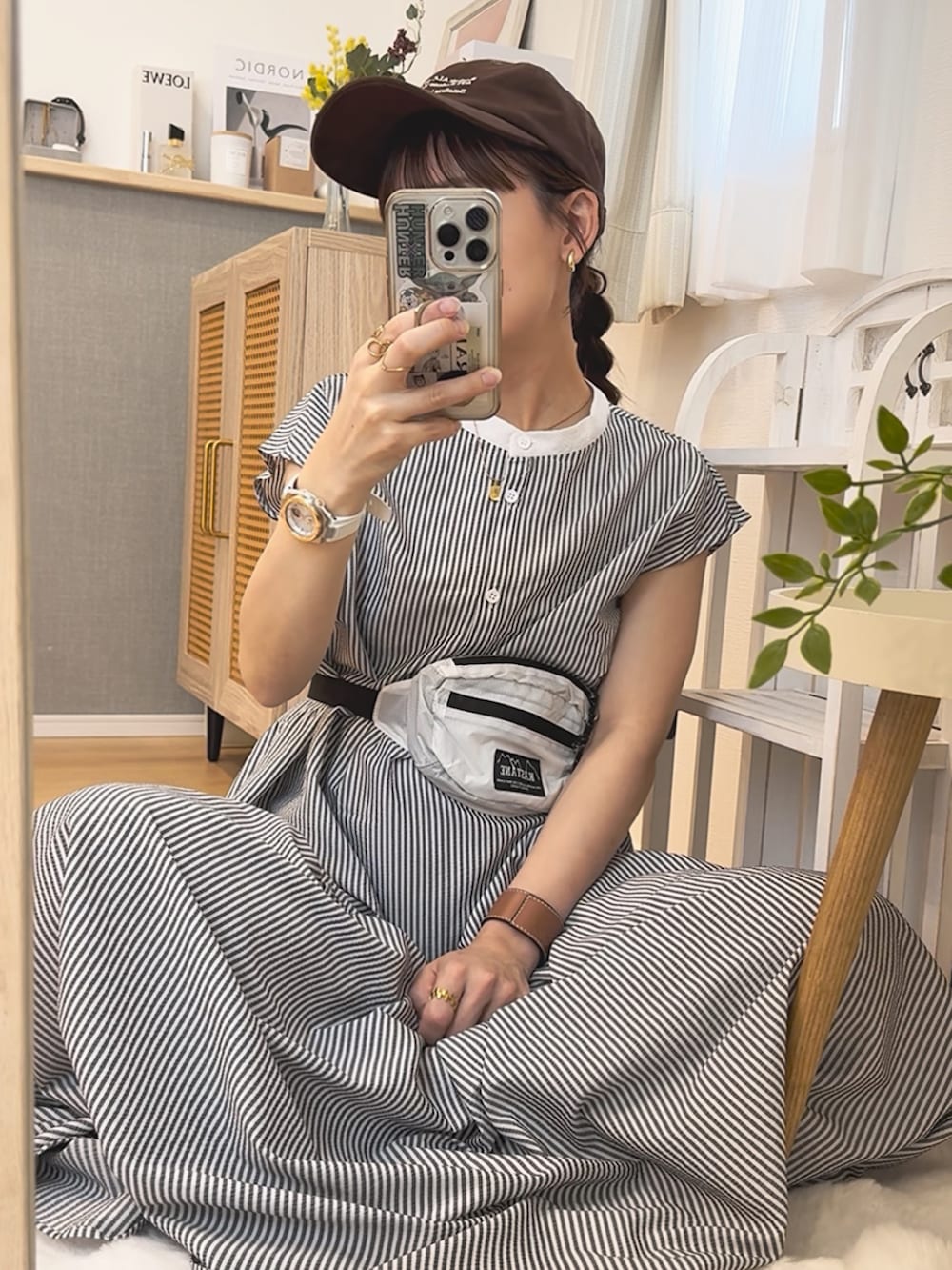 ブラック系のワンピース、ブラック系のサンダル、ブラウン系のキャップを着用したレディースの夏コーディネートの2枚目の写真