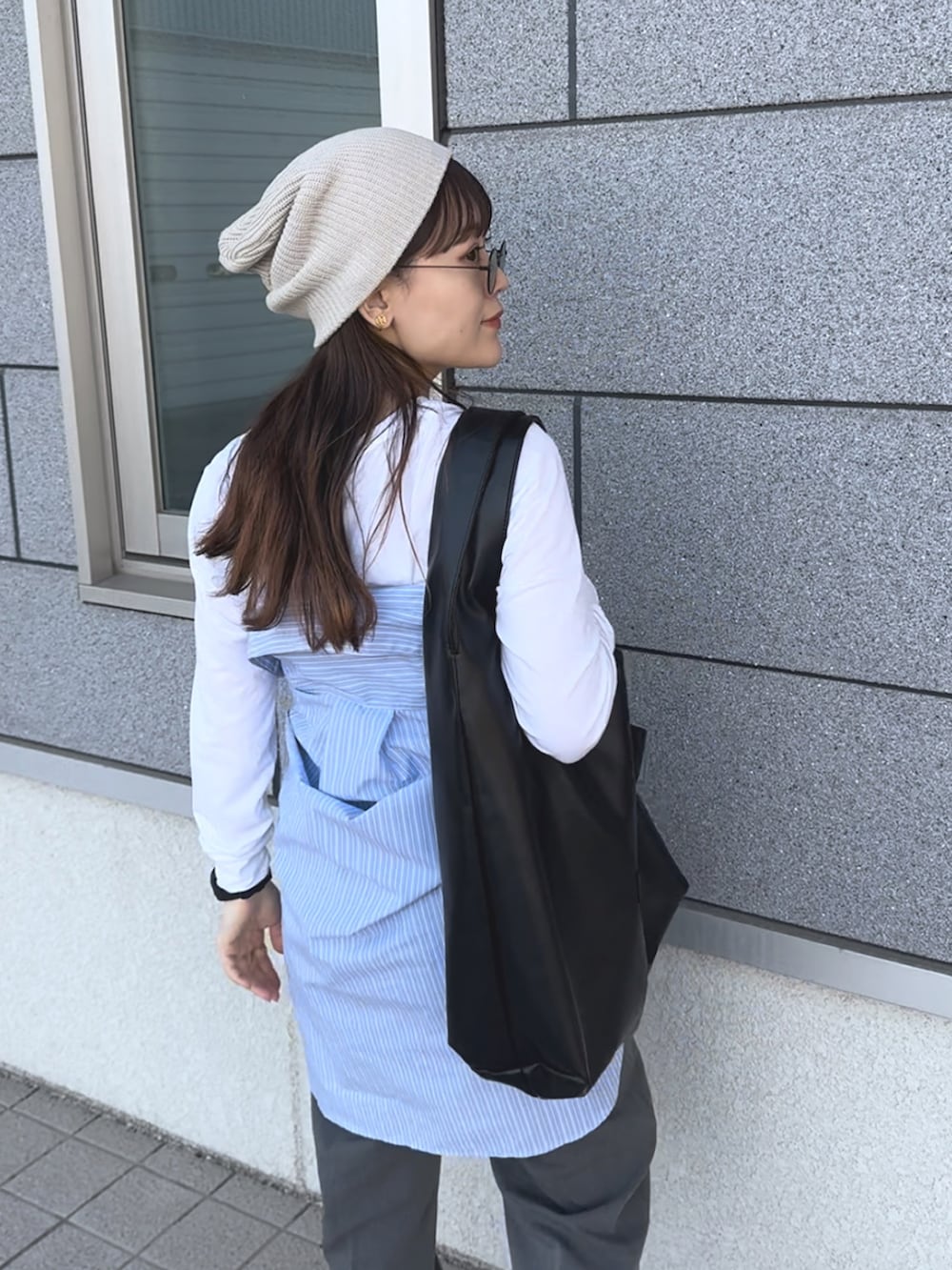 ベージュ系のスニーカー、ブルー系のシャツ/ブラウス、グレー系のパンツを着用したレディースの春コーディネートの3枚目の写真