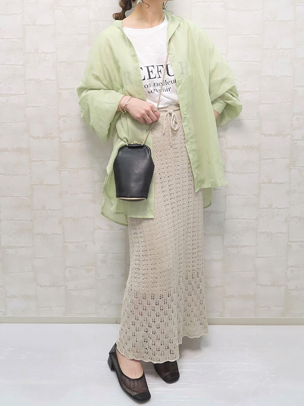 ベージュ系のスカート、ホワイト系のTシャツ/カットソー、ブラック系のパンプスを着用したレディースの春コーディネートの4枚目の写真