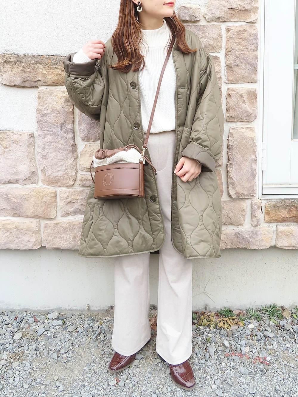 グリーン系のノーカラーコート、ベージュ系のワンピース、ホワイト系のTシャツ/カットソーを着用したレディースの秋コーディネートの2枚目の写真