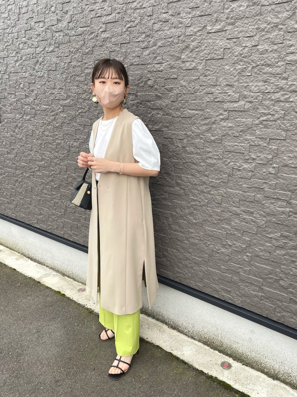 ベージュ系のベスト、グリーン系のその他パンツ、ホワイト系のTシャツ/カットソーを着用したレディースの夏コーディネートの4枚目の写真