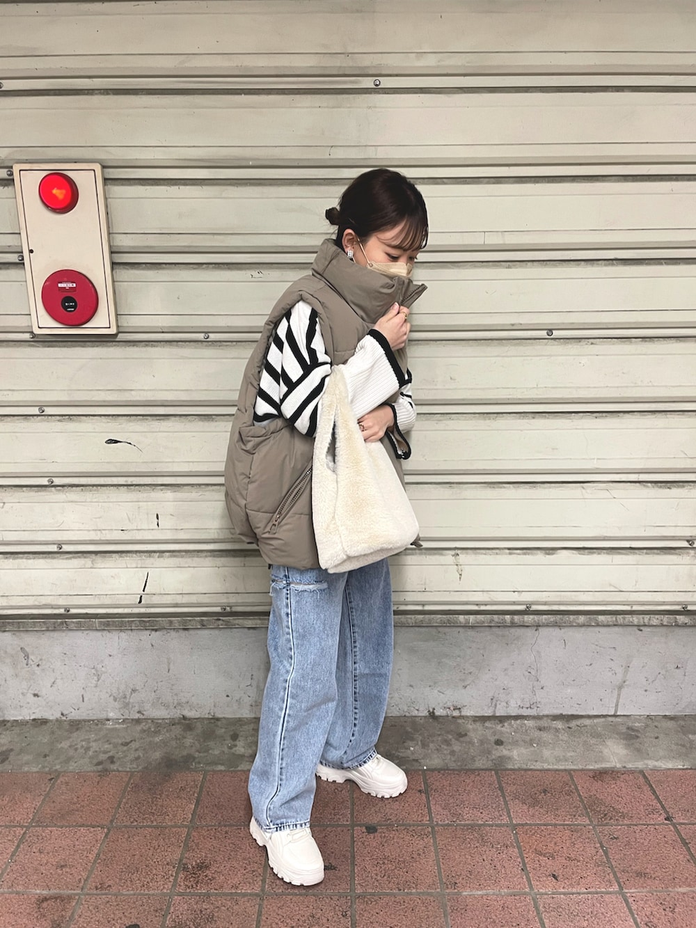 ホワイト系のニット/セーター、その他のデニムパンツ、ベージュ系のダウンベストを着用したレディースの冬コーディネートの4枚目の写真