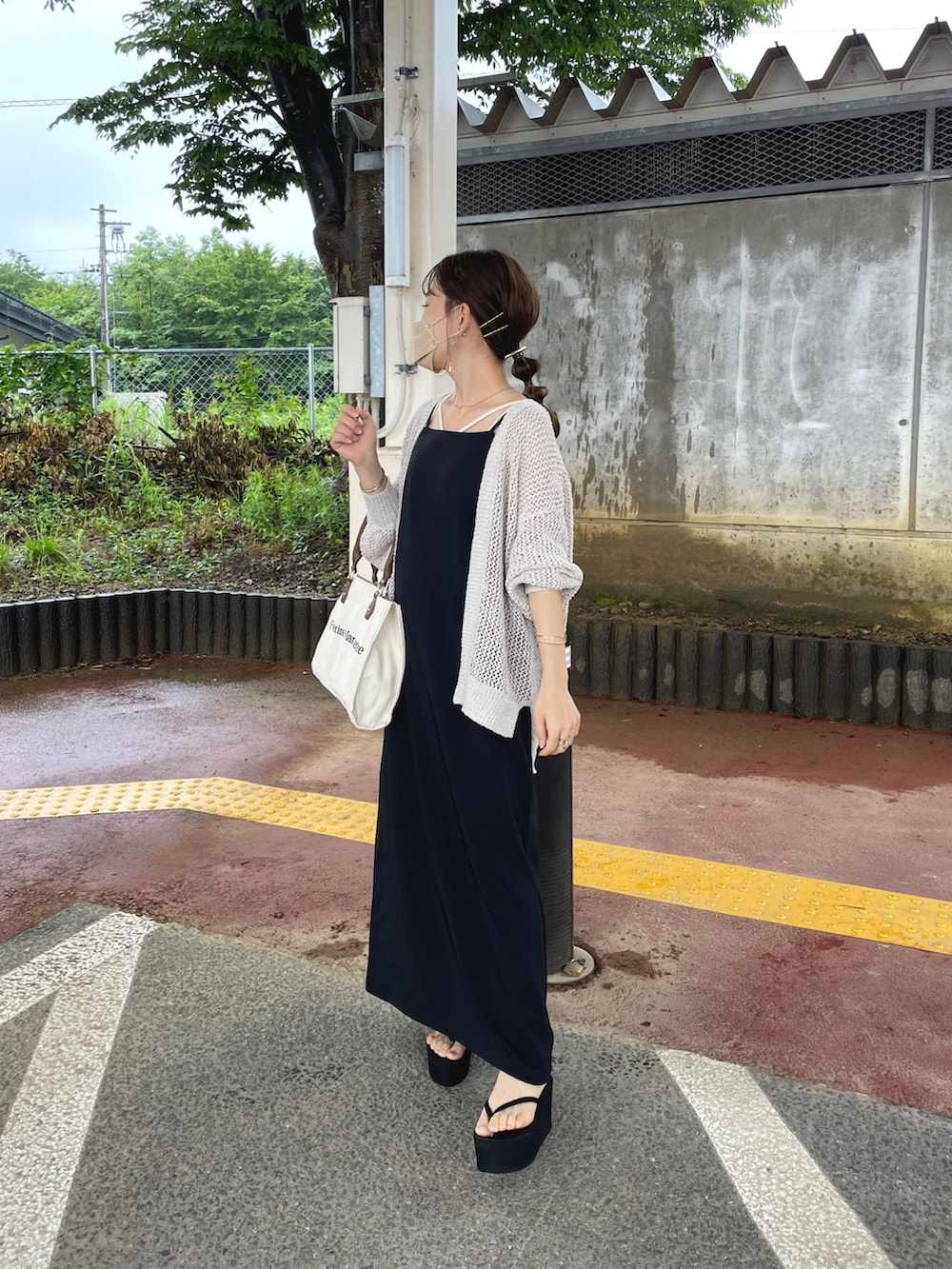 ホワイト系のカーディガン/ボレロ、ブラック系のワンピース、ホワイト系のキャミソールを着用したレディースの夏コーディネートの5枚目の写真