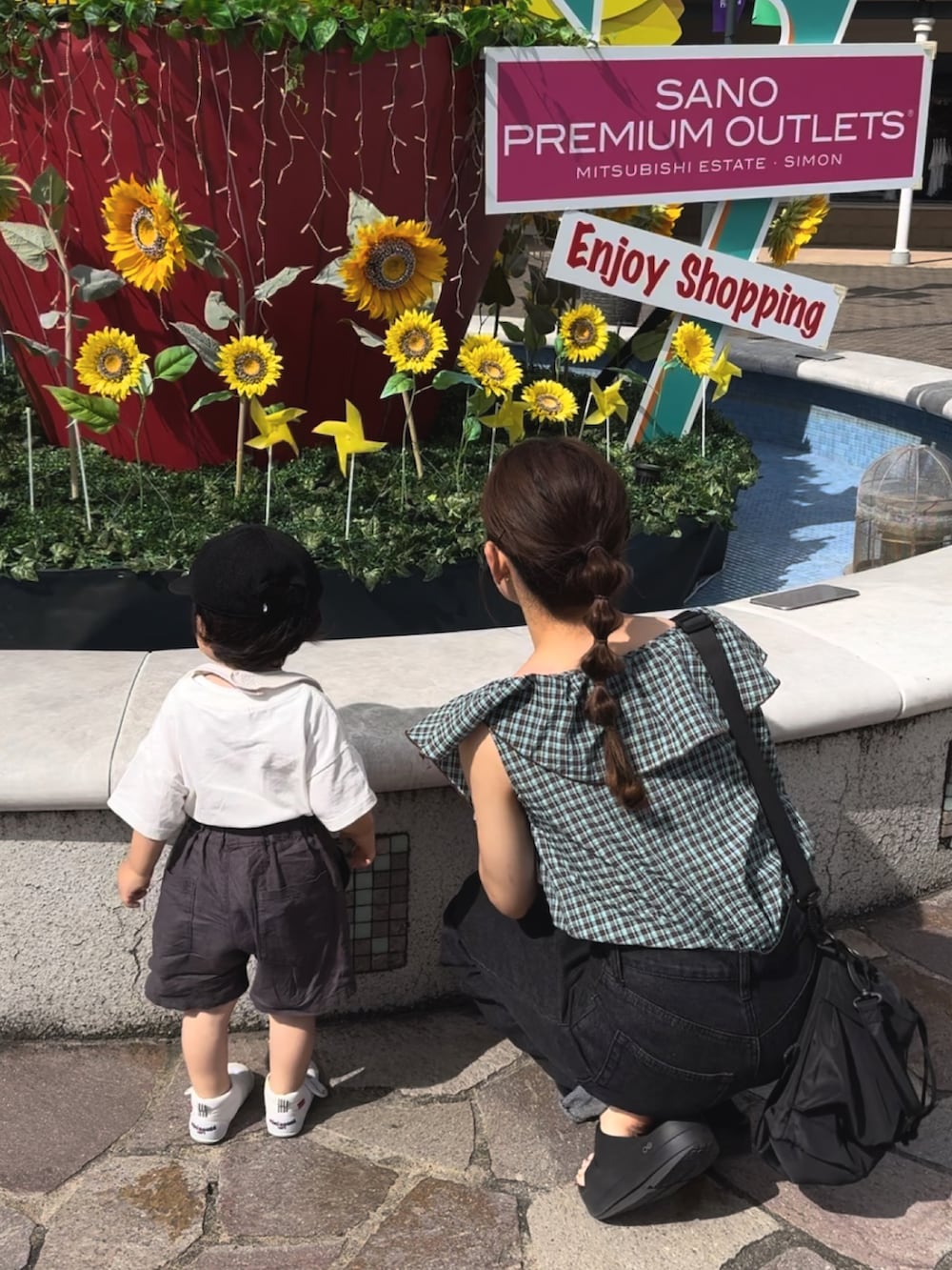 ブラック系のサンダル、グリーン系のトップス、ブラック系のパンツを着用したレディースの夏コーディネートの2枚目の写真