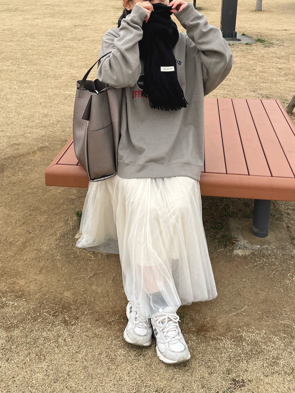 ベージュ系のスウェット、ホワイト系のスカート、ホワイト系のスニーカーを着用したレディースの冬コーディネートの3枚目の写真