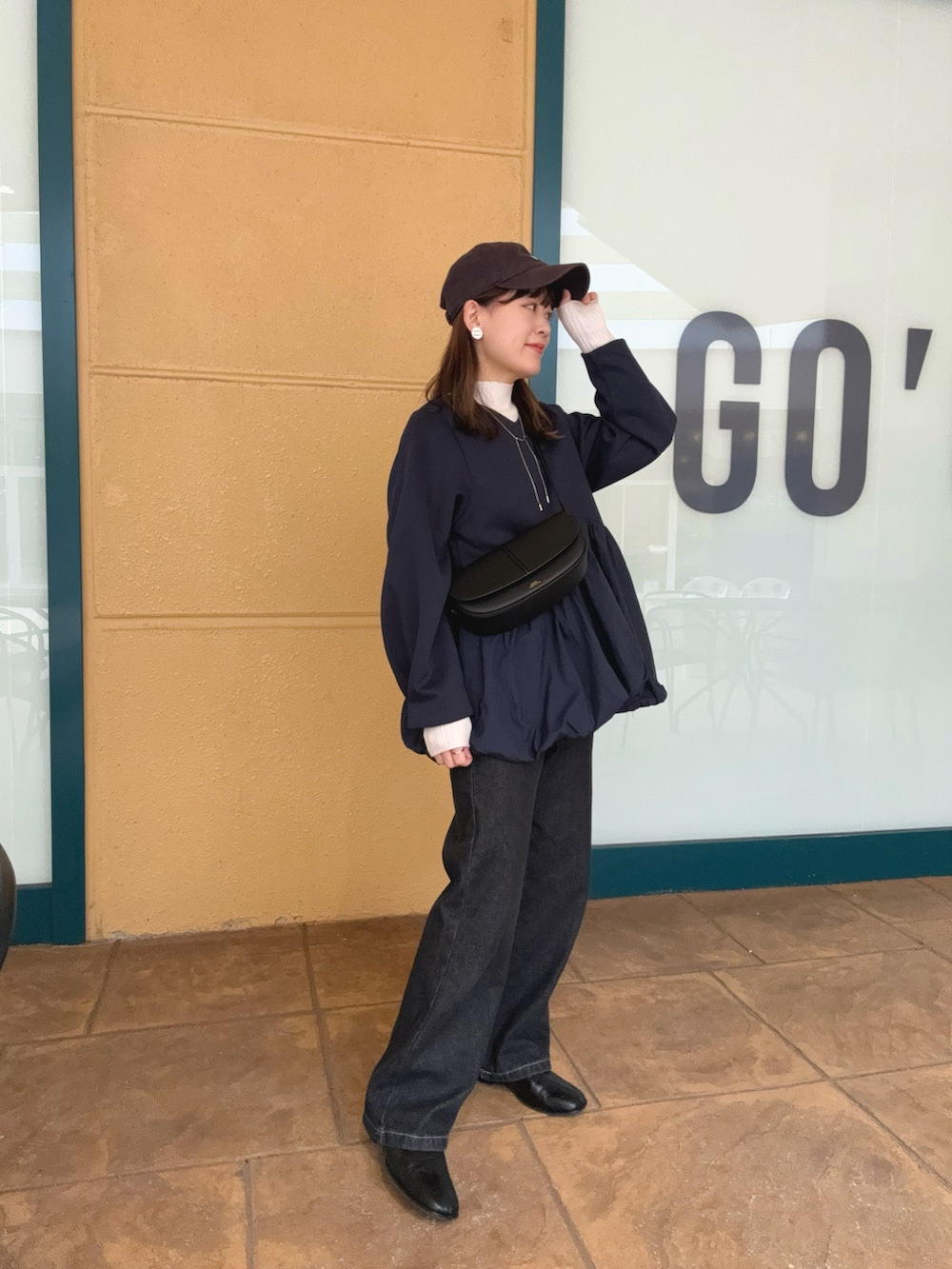 ブルー系のTシャツ/カットソー、ブラック系のデニムパンツ、ブラック系のショルダーバッグを着用したレディースの秋コーディネートの5枚目の写真