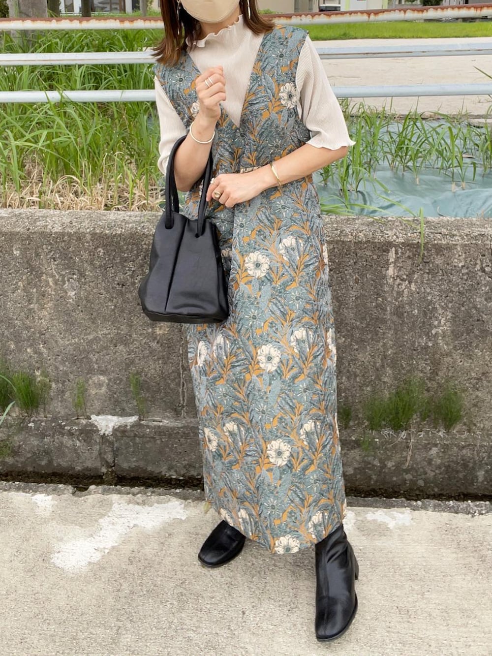 イエロー系のワンピース、ホワイト系のTシャツ/カットソー、ブラック系のハンドバッグを着用したレディースの秋コーディネートの3枚目の写真