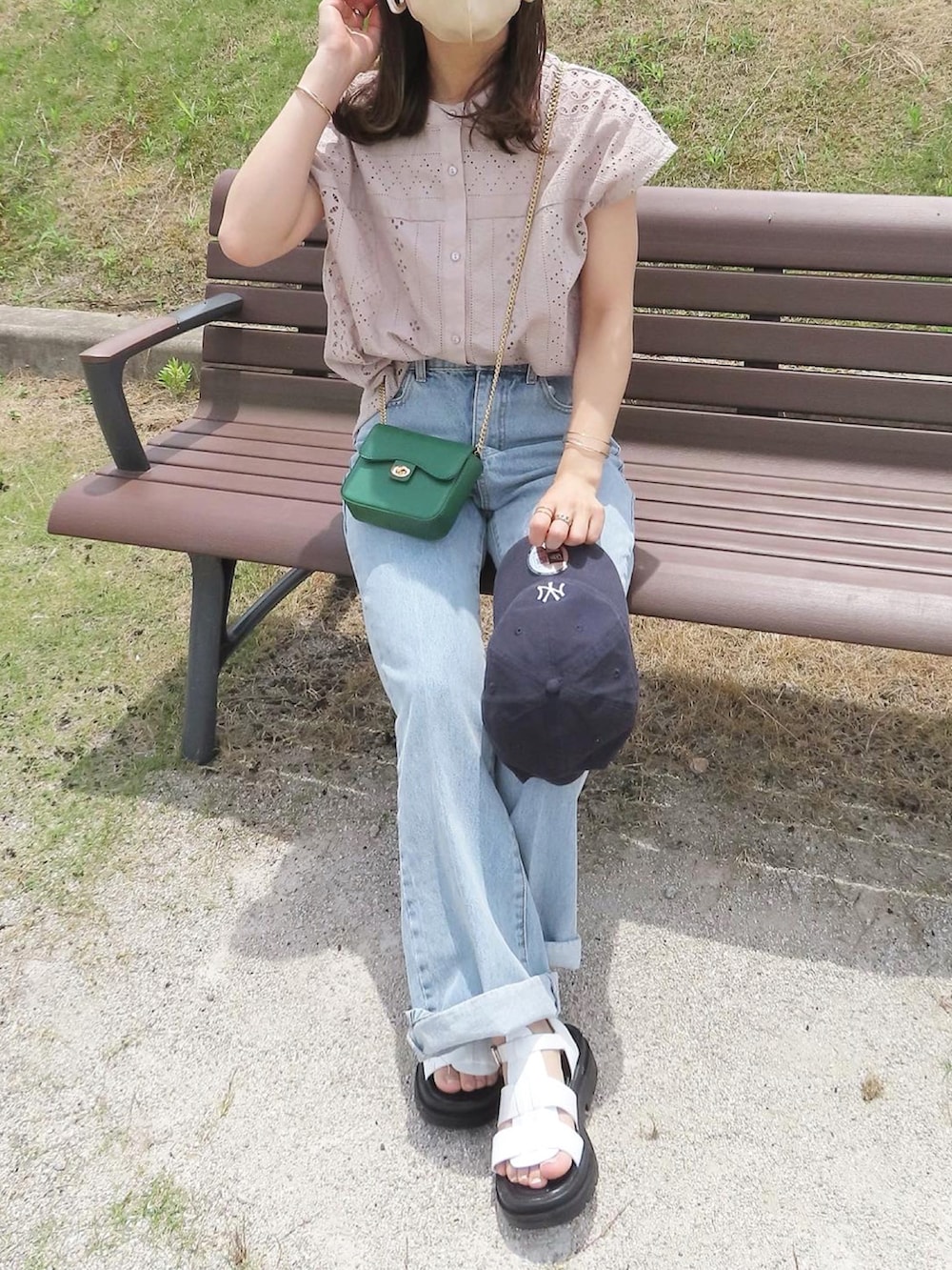グレー系のシャツ/ブラウス、ブルー系のデニムパンツ、グリーン系のショルダーバッグを着用したレディースの夏コーディネートの2枚目の写真