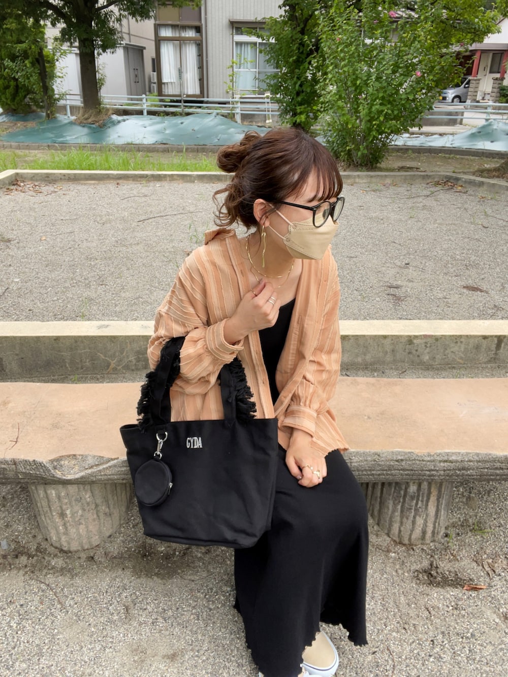 ブラック系のトートバッグ、オレンジ系のシャツ/ブラウス、ブラック系のワンピースを着用したレディースの夏コーディネートの2枚目の写真