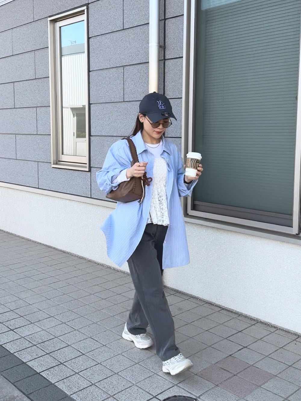 ブルー系のシャツ/ブラウス、ホワイト系のその他トップス、グレー系のパンツを着用したレディースの春コーディネートの2枚目の写真