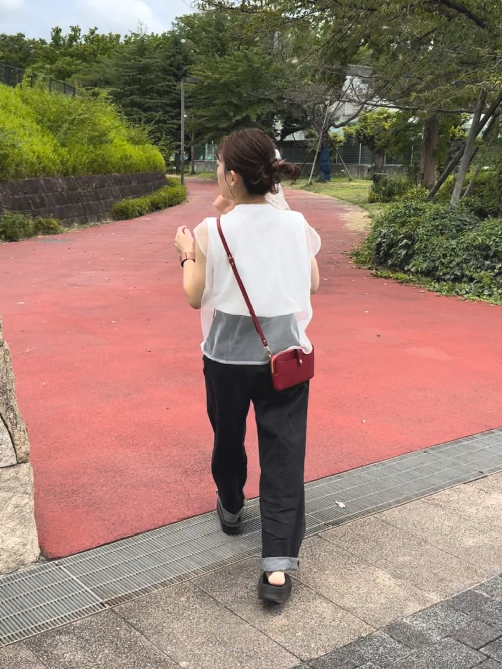 ブラック系のサンダル、レッド系のショルダーバッグ、ホワイト系のトップスを着用したレディースの夏コーディネートの2枚目の写真