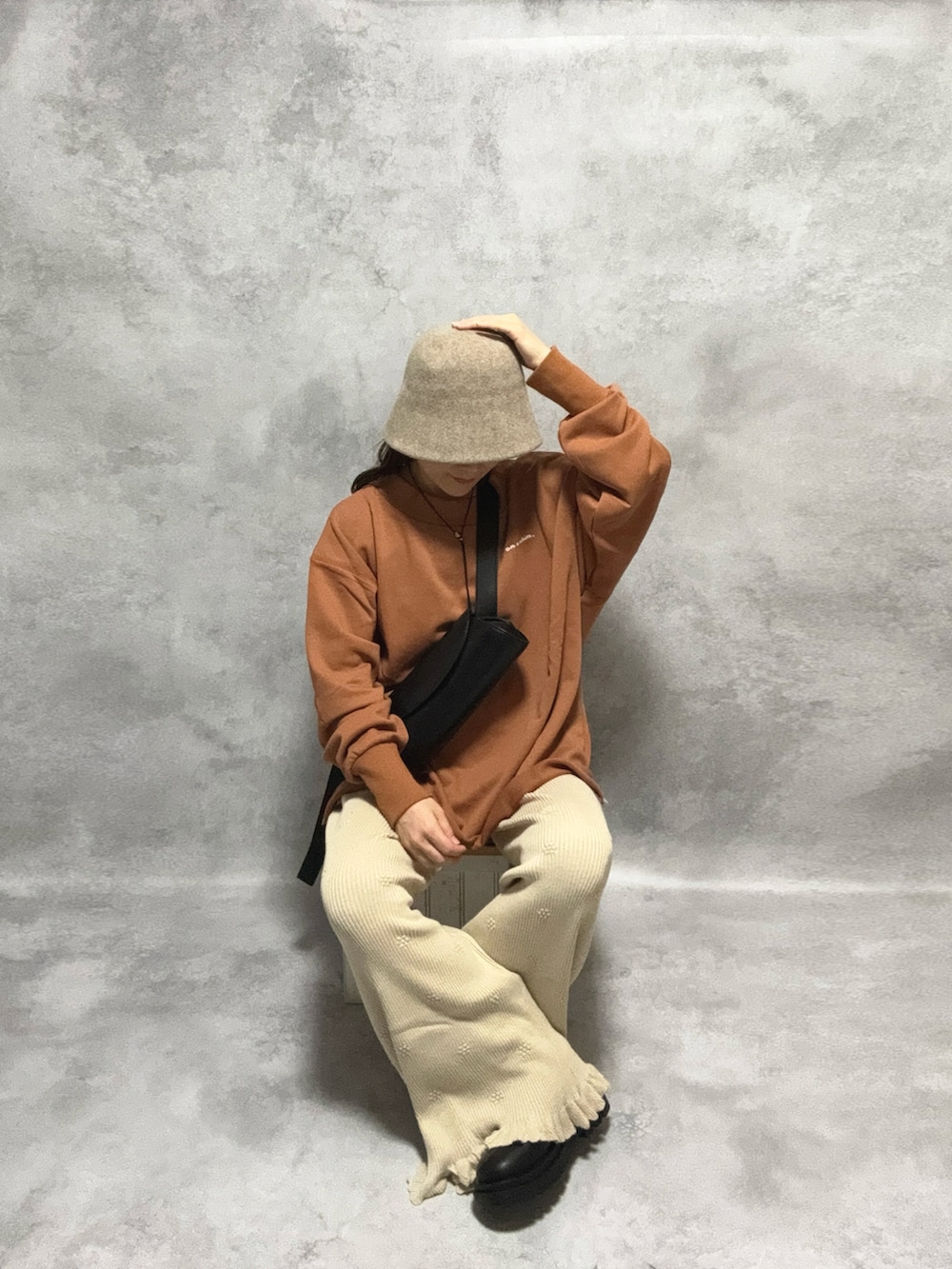 ブラウン系のスウェット、ホワイト系のその他パンツ、ブラック系のショルダーバッグを着用したレディースの秋コーディネートの5枚目の写真