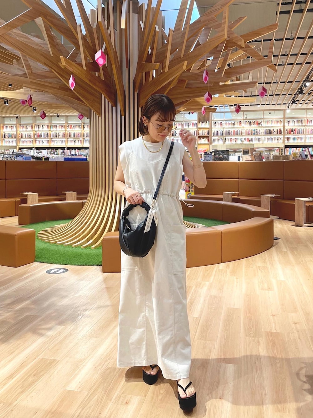 ベージュ系のワンピース/ドレス、ホワイト系のニット/セーター、ブラック系のハンドバッグを着用したレディースの夏コーディネートの5枚目の写真