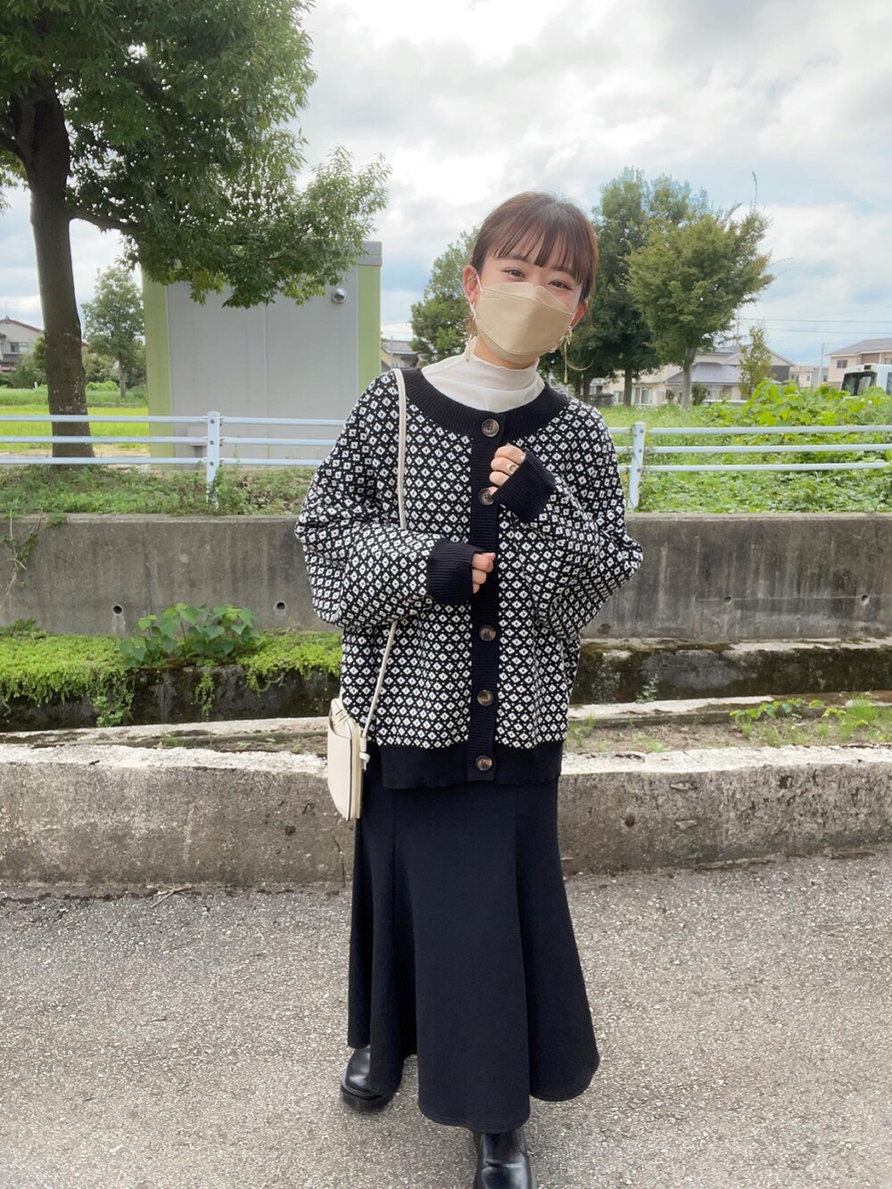 ブラック系のカーディガン/ボレロ、ホワイト系のTシャツ/カットソー、ブラック系のスカートを着用したレディースの秋コーディネートの2枚目の写真