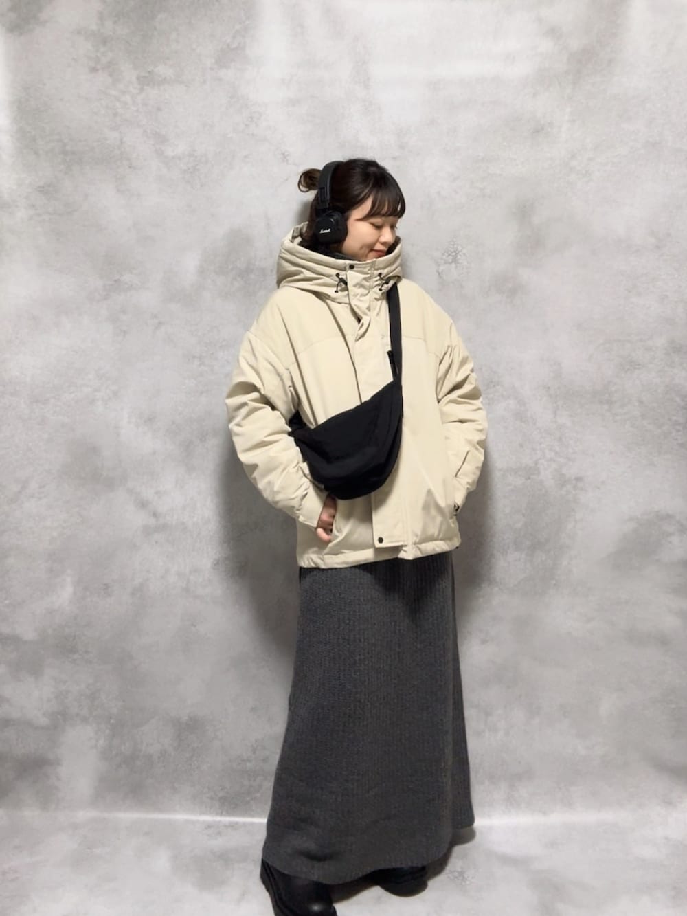 ベージュ系のダウンジャケット/コート、グレー系のワンピース、ブラック系のショルダーバッグを着用したレディースの秋コーディネートの3枚目の写真