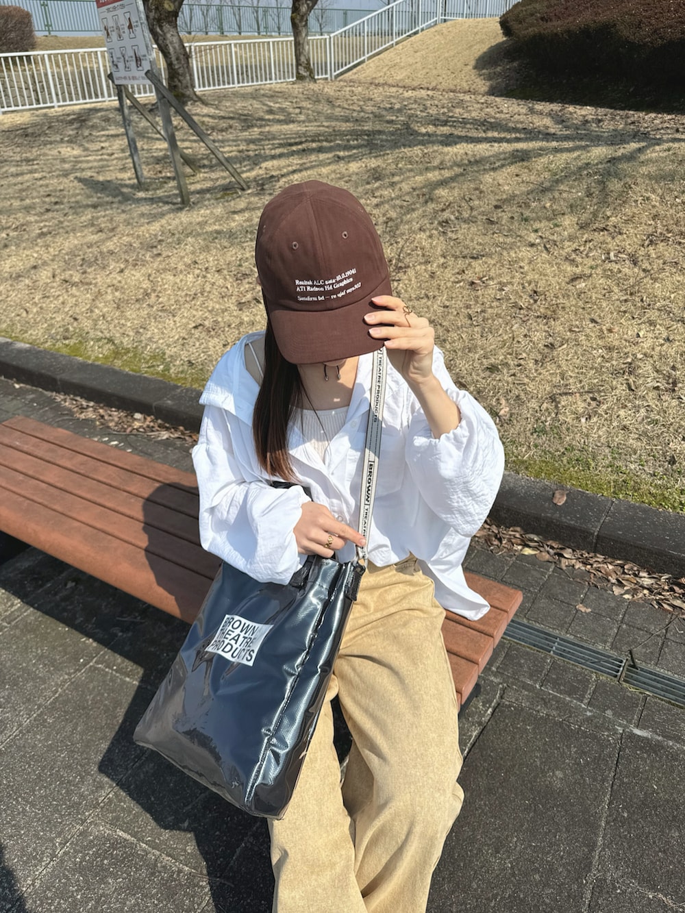 ホワイト系のシャツ/ブラウス、ブラック系のトートバッグ、ベージュ系のパンツを着用したレディースの春コーディネートの2枚目の写真