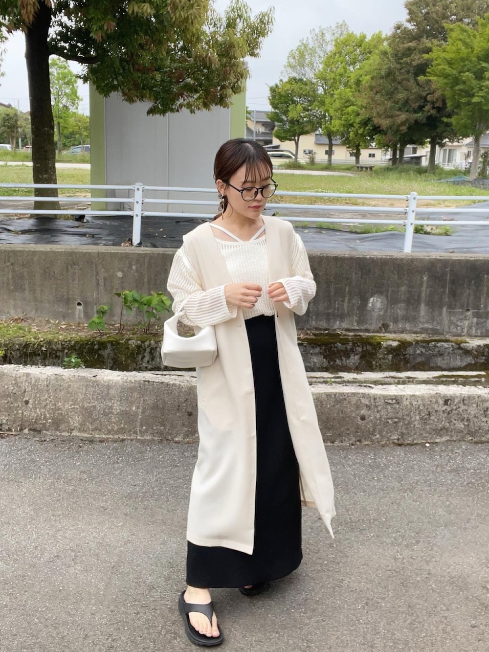 ホワイト系のベスト、ベージュ系のTシャツ/カットソー、ホワイト系のキャミソールを着用したレディースの春コーディネートの3枚目の写真