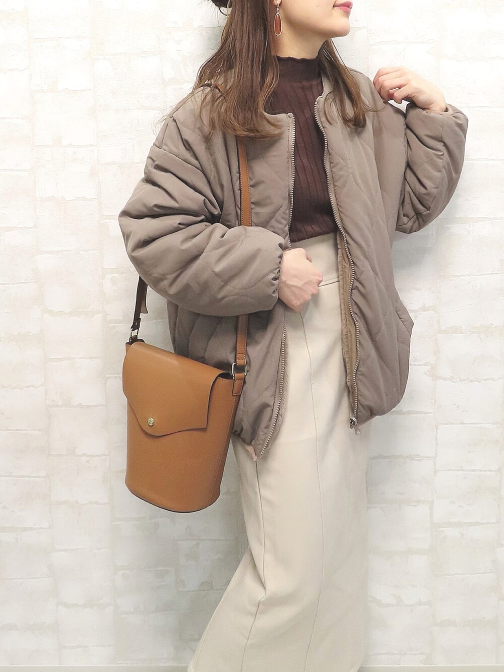 ブラウン系のブルゾン、ブラウン系のニット/セーター、ベージュ系のスカートを着用したレディースの秋コーディネートの2枚目の写真