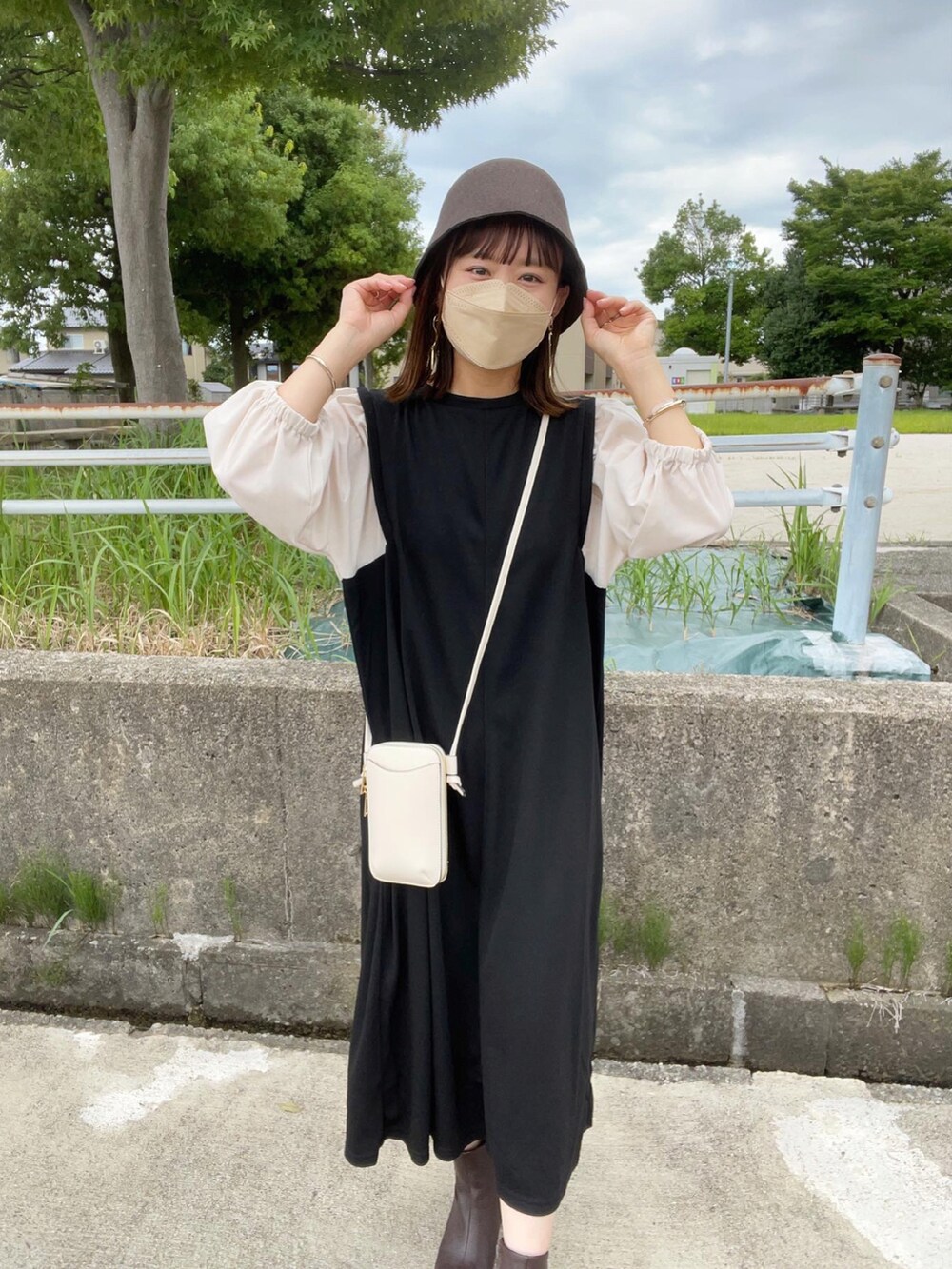 ブラック系のワンピース、ブラウン系のブーツ、ブラウン系のハットを着用したレディースの秋コーディネートの3枚目の写真