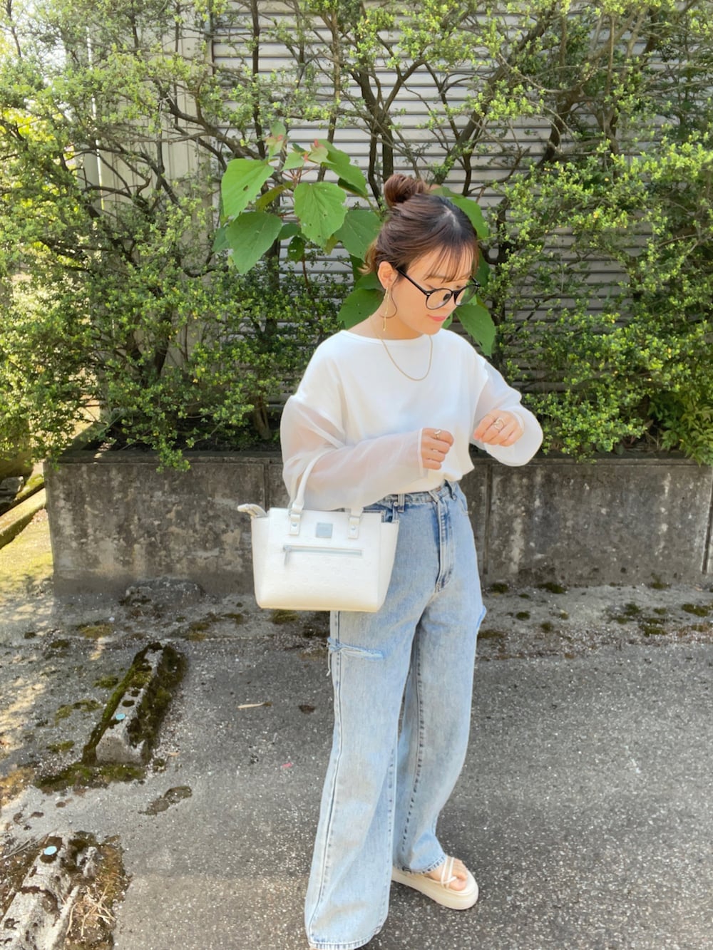 ホワイト系のハンドバッグ、ホワイト系のTシャツ/カットソー、その他のデニムパンツを着用したレディースの春コーディネートの2枚目の写真