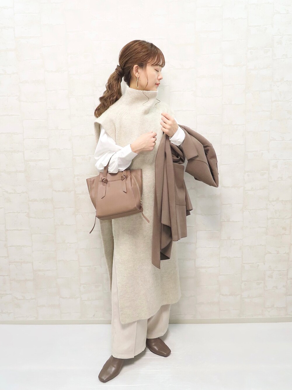 ブラウン系のその他アウター、ホワイト系のベスト、ホワイト系のその他パンツを着用したレディースの秋コーディネートの2枚目の写真