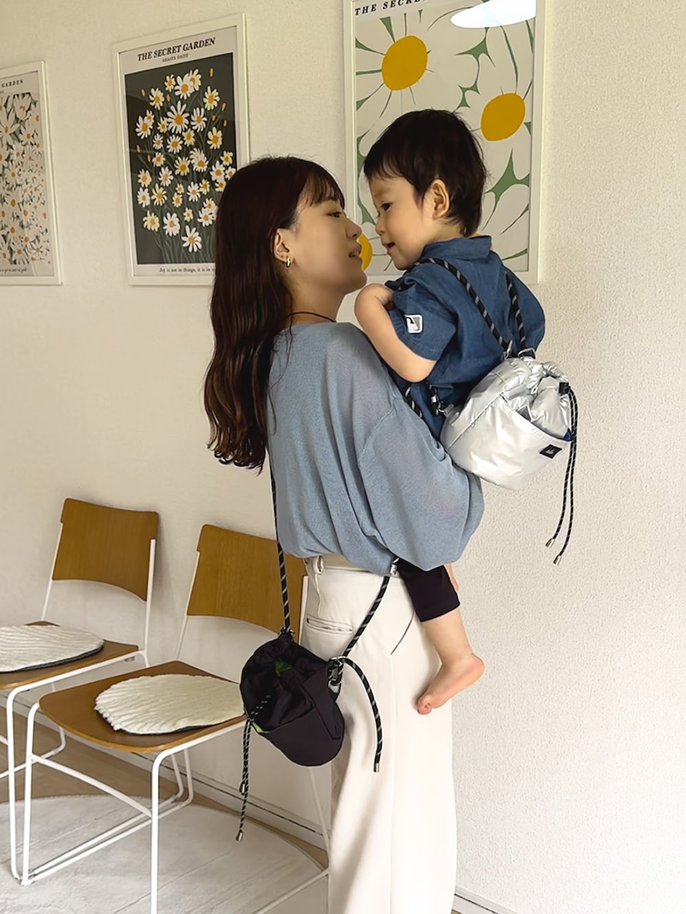 ブルー系のカーディガン/ボレロ、ホワイト系のスラックス、ブラック系のトートバッグを着用したレディースの秋コーディネートの2枚目の写真