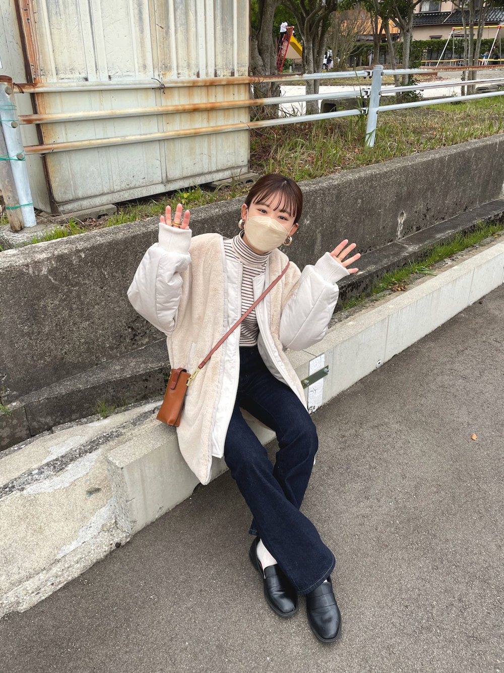 ベージュ系のブルゾン、ホワイト系のニット/セーター、ブルー系のデニムパンツを着用したレディースの冬コーディネートの3枚目の写真