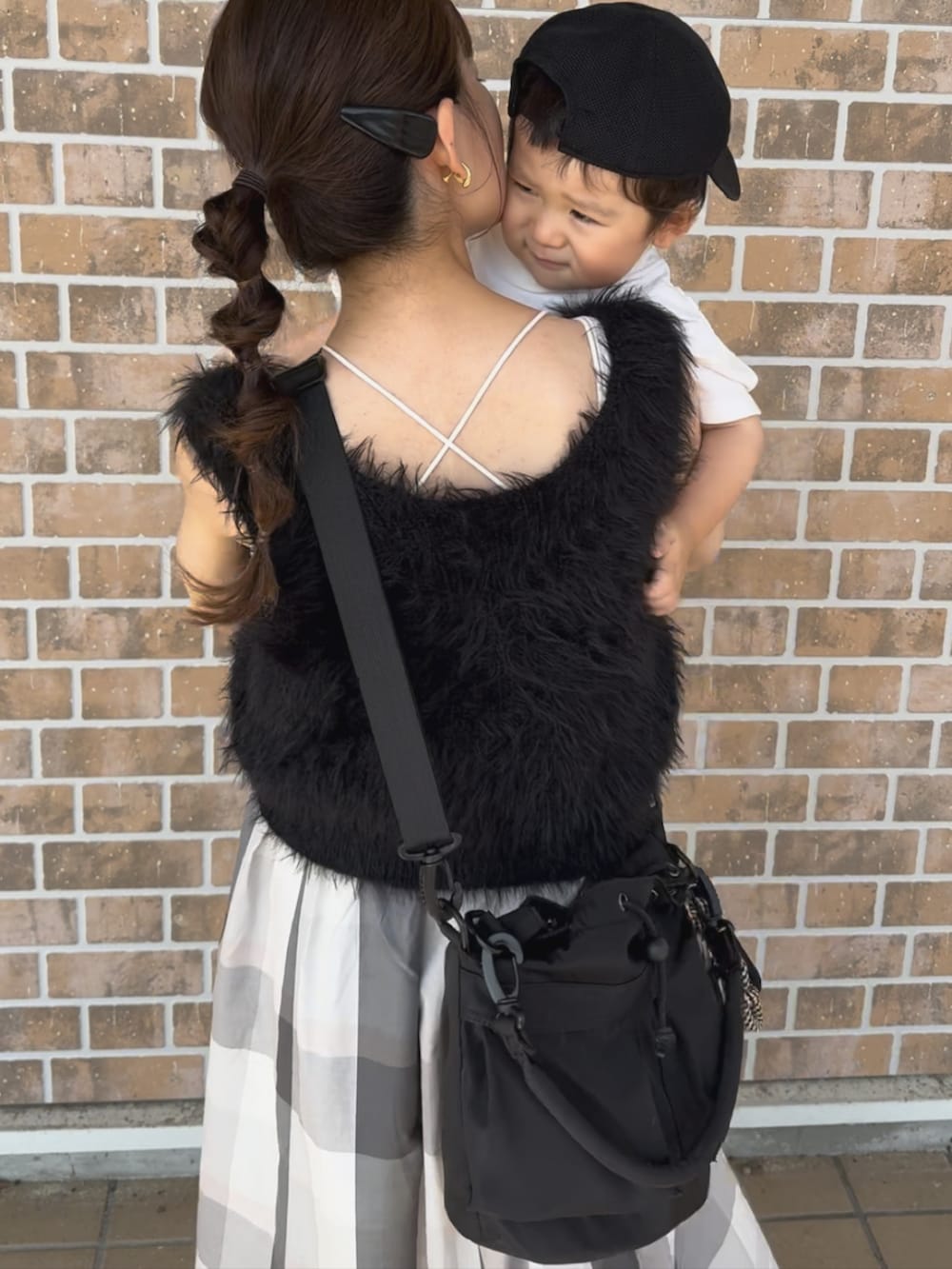 ブラック系のトップス、ベージュ系のスカート、ブラック系のバッグを着用したレディースの秋コーディネートの2枚目の写真