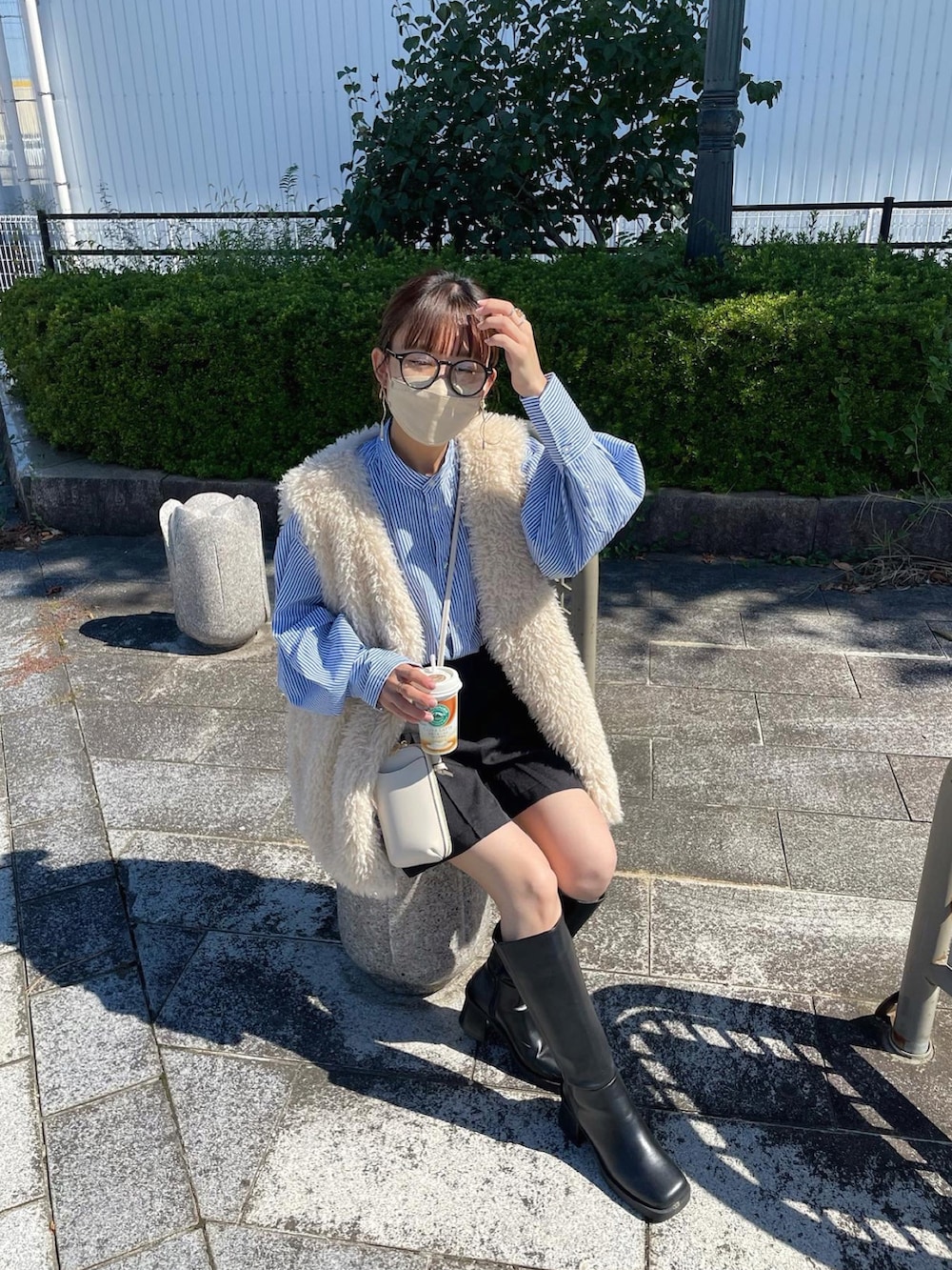 ブルー系のシャツ/ブラウス、ホワイト系のベスト、ブラック系のスラックスを着用したレディースの秋コーディネートの5枚目の写真