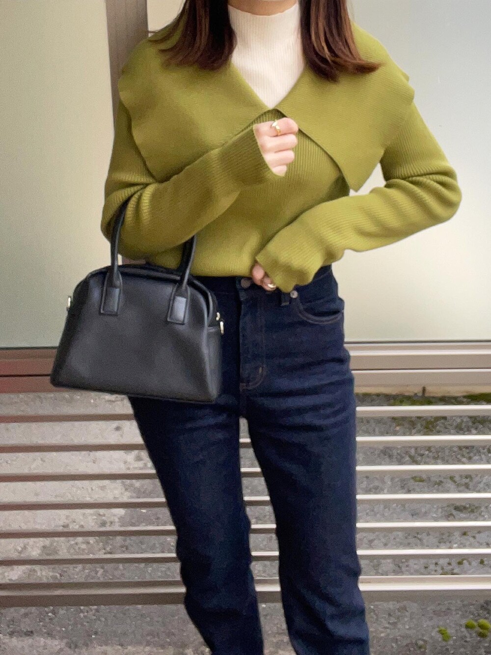 グリーン系のニット/セーター、ホワイト系のニット/セーター、ブルー系のデニムパンツを着用したレディースの冬コーディネートの4枚目の写真