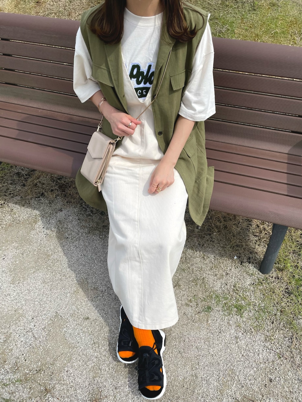 ベージュ系のTシャツ/カットソー、ホワイト系のジャンパースカート、グリーン系のベストを着用したレディースの夏コーディネートの2枚目の写真