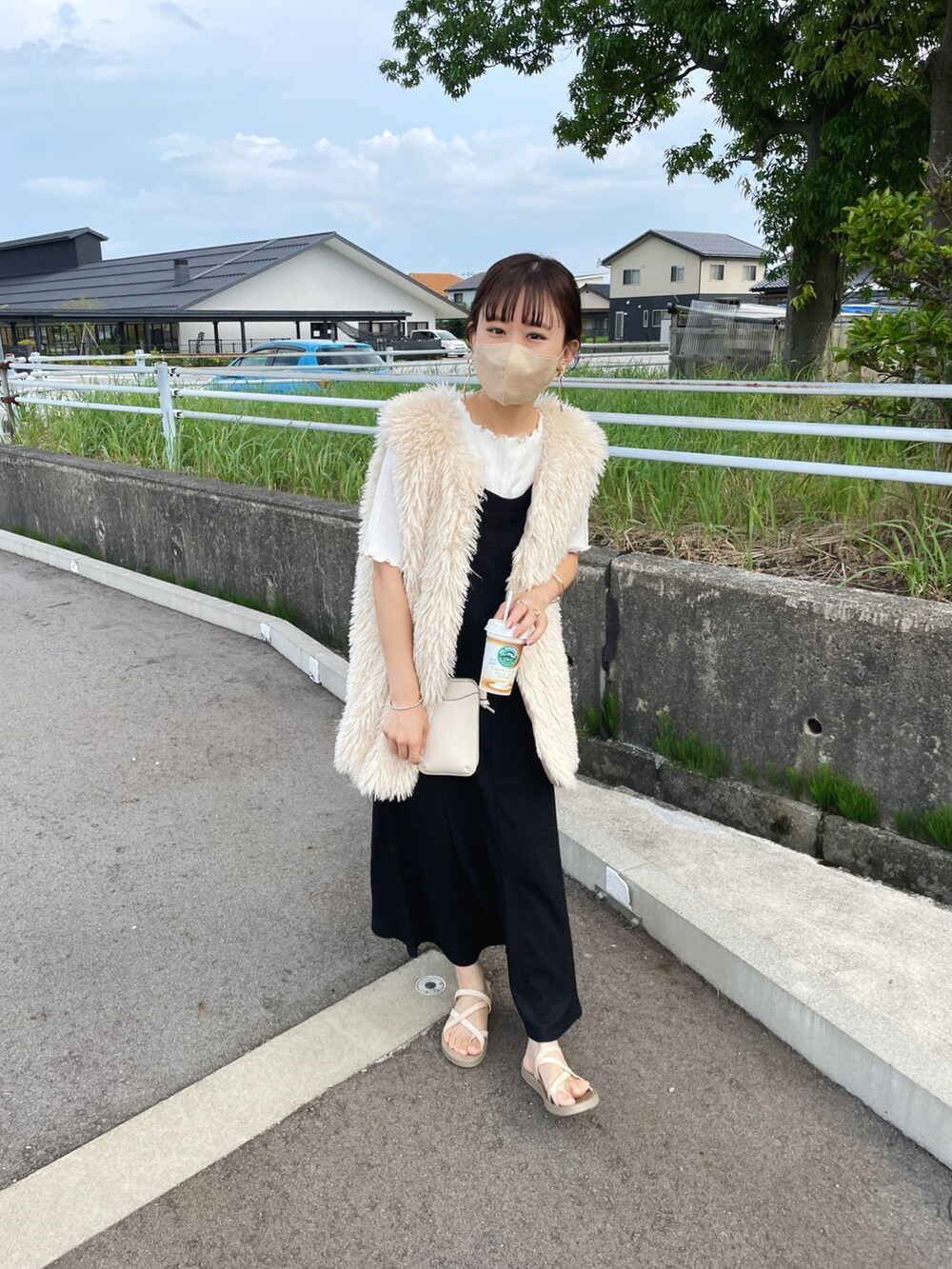 ホワイト系のベスト、ホワイト系のTシャツ/カットソー、ブラック系のワンピースを着用したレディースの夏コーディネートの5枚目の写真