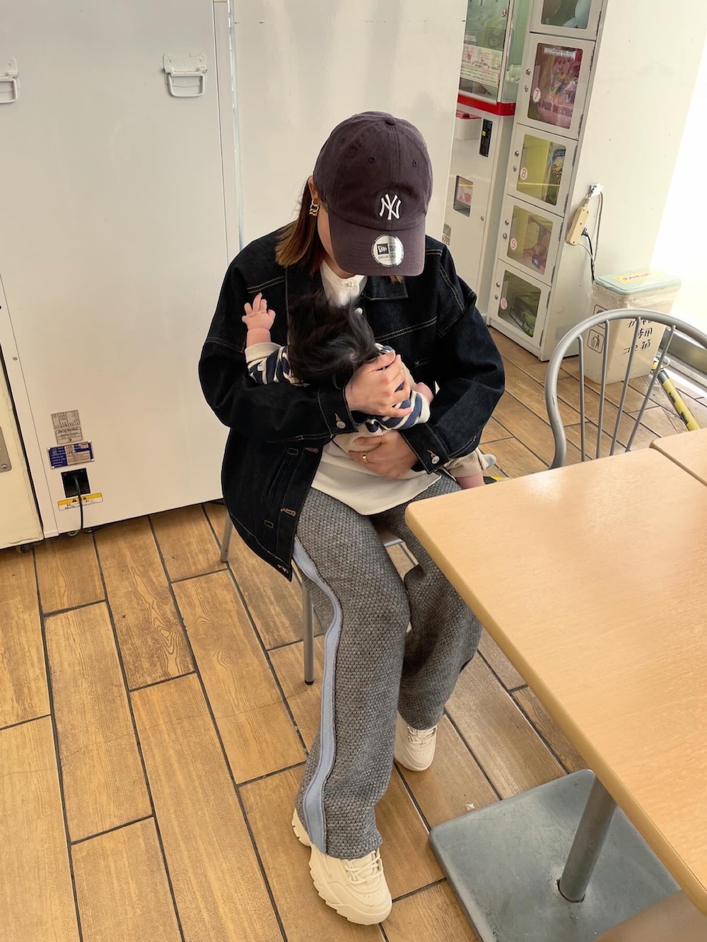 ブルー系のデニムジャケット、ホワイト系のシャツ/ブラウス、グレー系のパンツを着用したレディースの春コーディネートの4枚目の写真