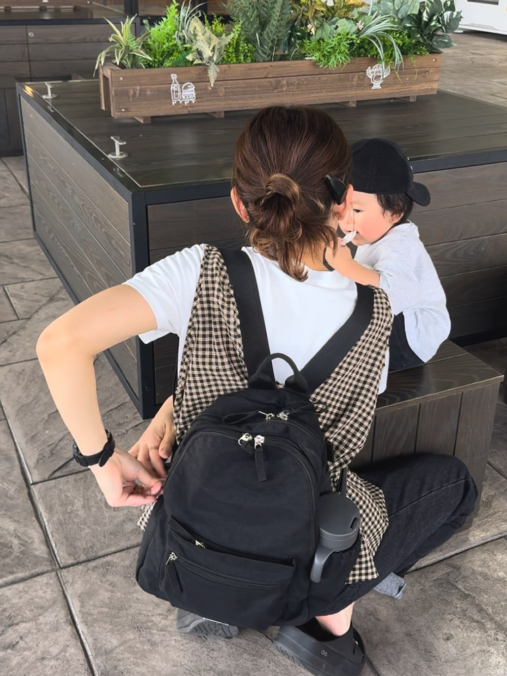 ブラック系のサンダル、ブラウン系のベスト、ブルー系のデニムパンツを着用したレディースの夏コーディネートの4枚目の写真