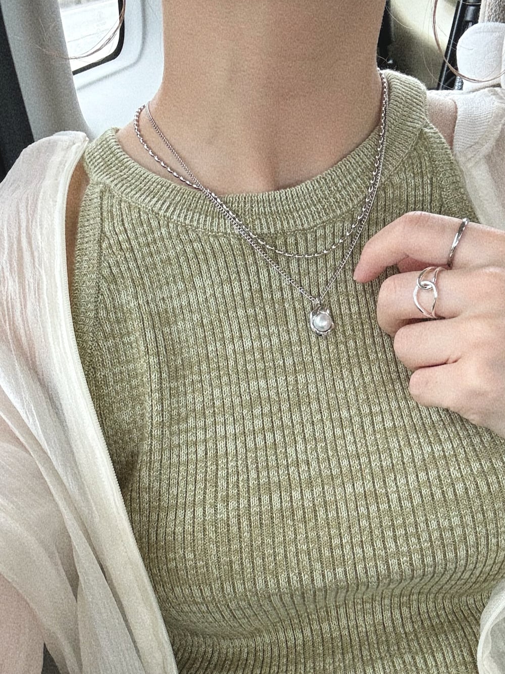 グリーン系のタンクトップ、ブラック系のスカート、ホワイト系のショルダーバッグを着用したレディースの夏コーディネートの4枚目の写真