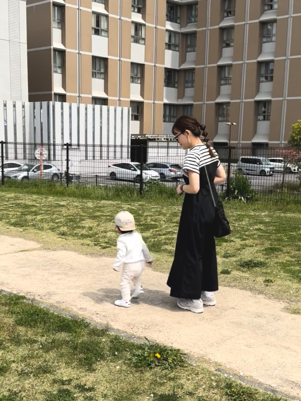 ブラック系のワンピース、ブルー系のシャツ/ブラウス、ホワイト系のスニーカーを着用したレディースの春コーディネートの3枚目の写真