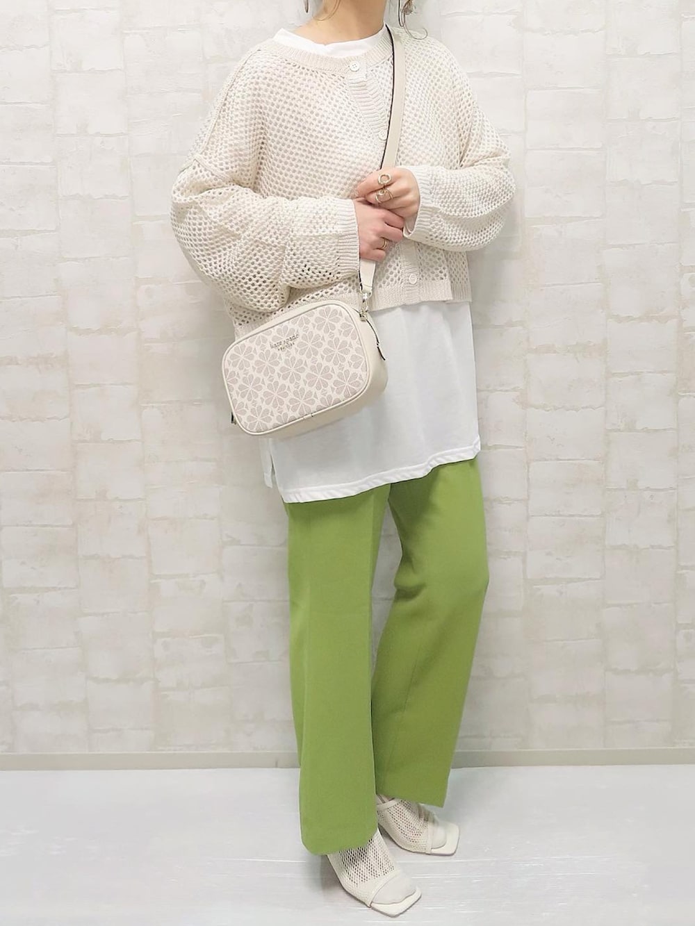 ホワイト系のアンサンブル、グリーン系のその他パンツ、ホワイト系のショルダーバッグを着用したレディースの春コーディネートの3枚目の写真