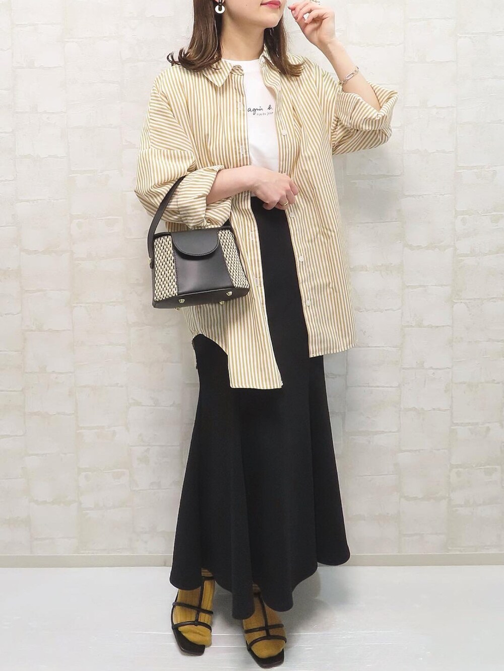 ブラック系のサンダル、イエロー系のシャツ/ブラウス、ホワイト系のTシャツ/カットソーを着用したレディースの春コーディネートの4枚目の写真