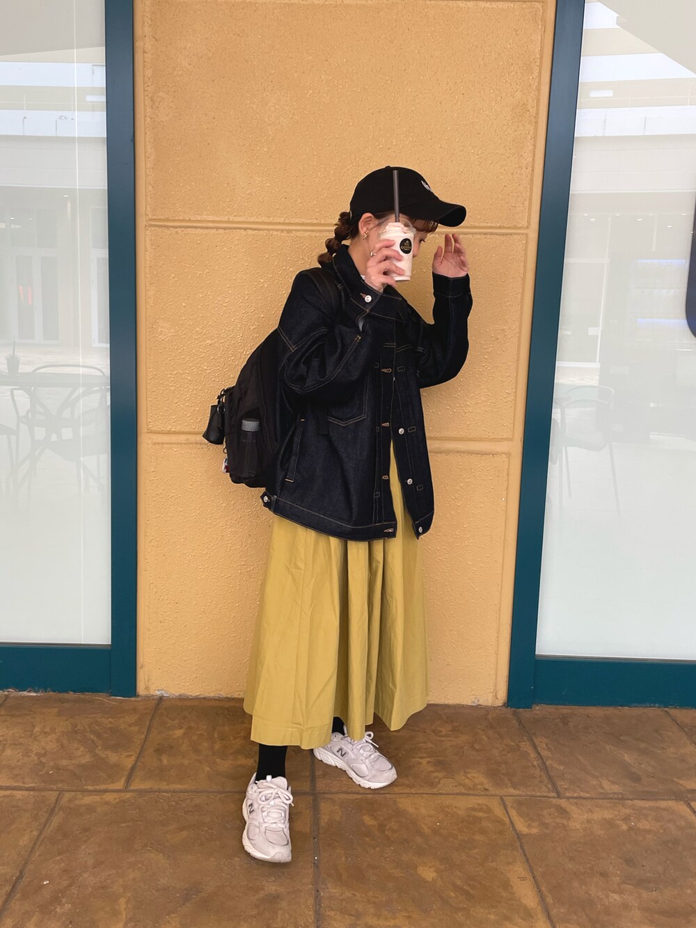 イエロー系のスカート、ホワイト系のTシャツ/カットソー、ブルー系のデニムジャケットを着用したレディースの春コーディネートの2枚目の写真