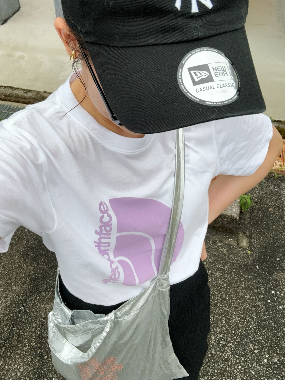 ホワイト系のTシャツ/カットソー、ブラック系のスカート、シルバー系のトートバッグを着用したレディースの夏コーディネートの3枚目の写真