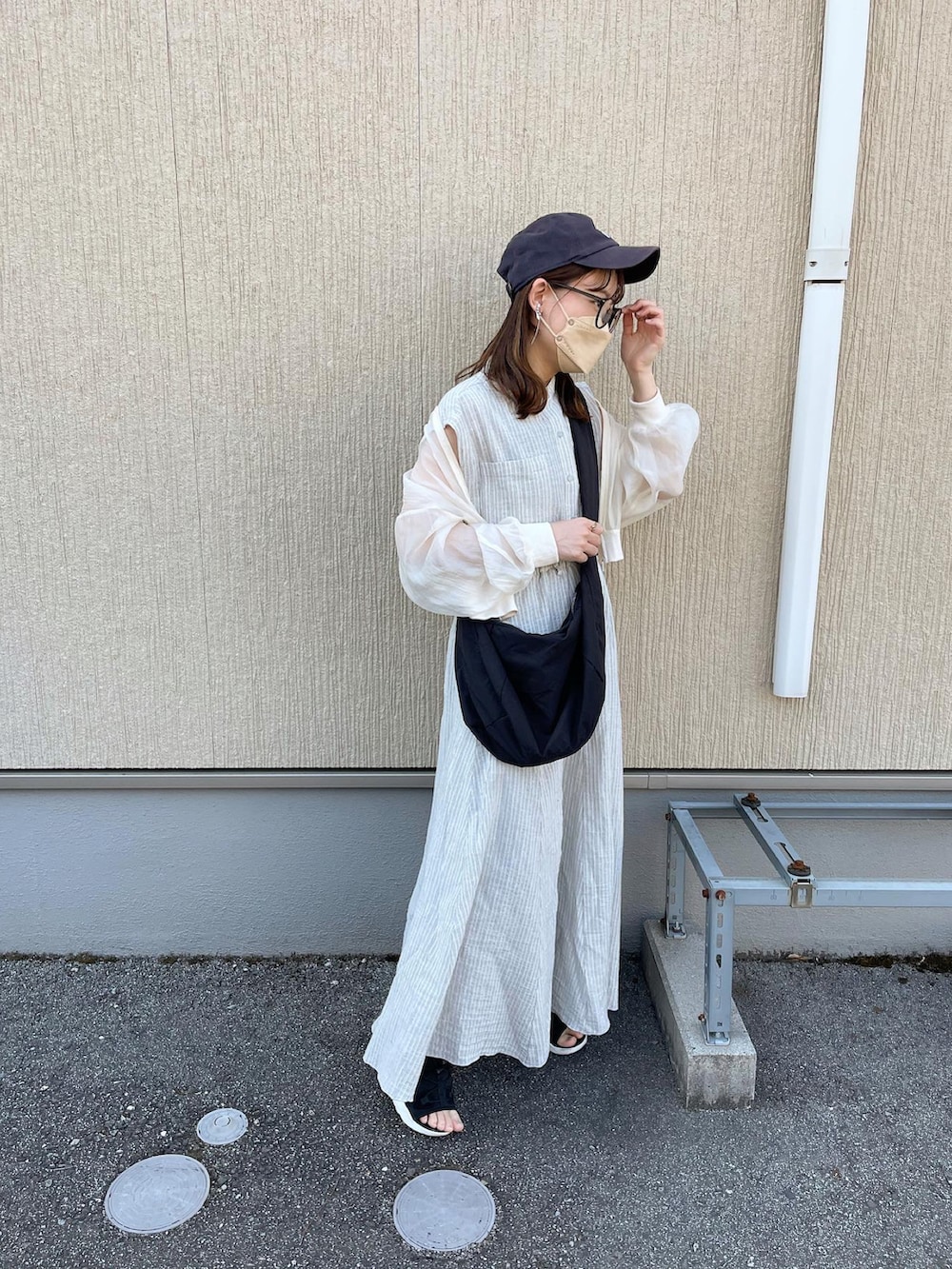 グレー系のシャツ/ブラウス、グレー系のスカート、ブラック系のショルダーバッグを着用したレディースの春コーディネートの4枚目の写真
