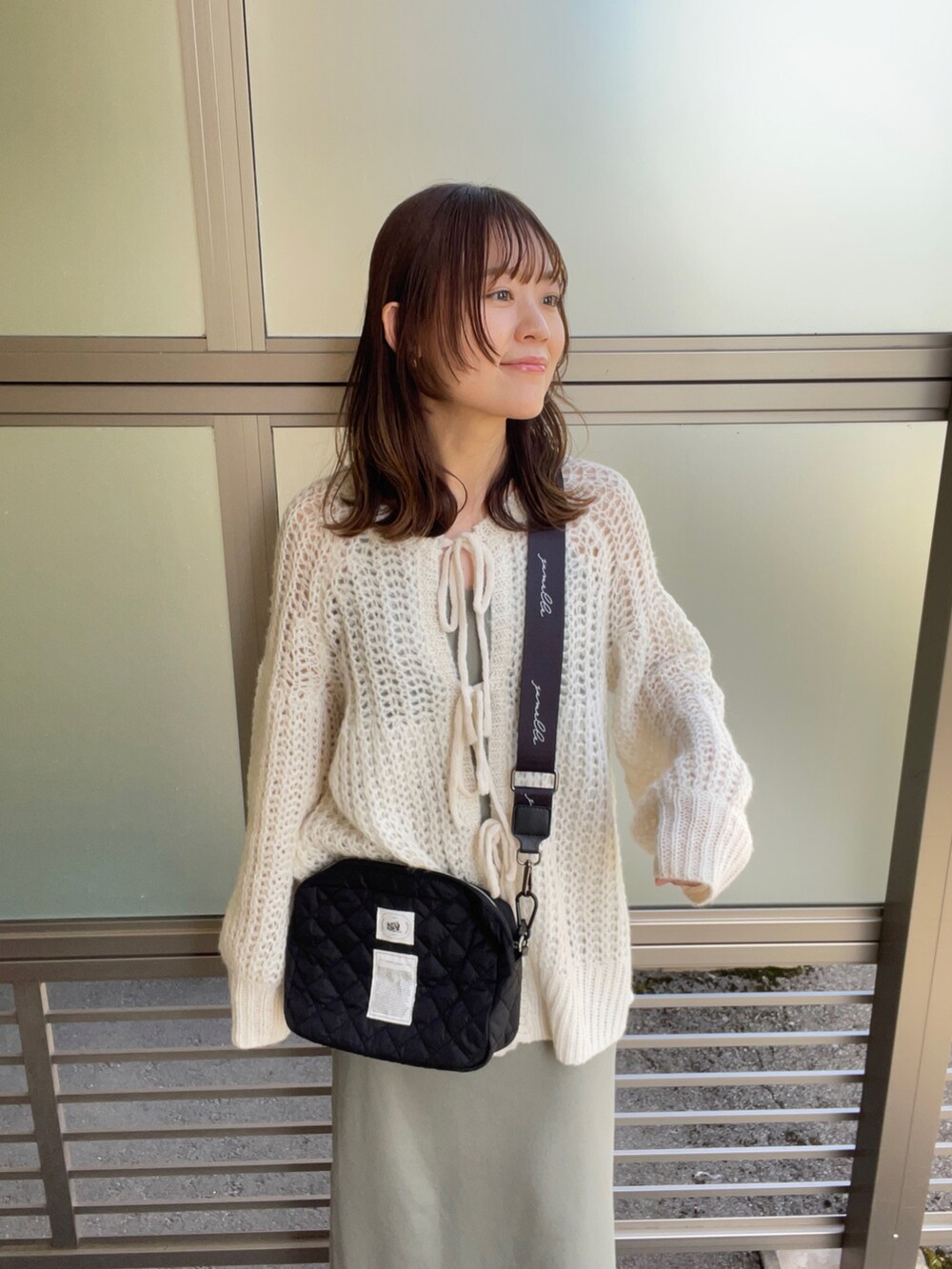 ホワイト系のカーディガン/ボレロ、ブラック系のショルダーバッグ、グリーン系のワンピース/ドレスを着用したレディースの春コーディネートの5枚目の写真