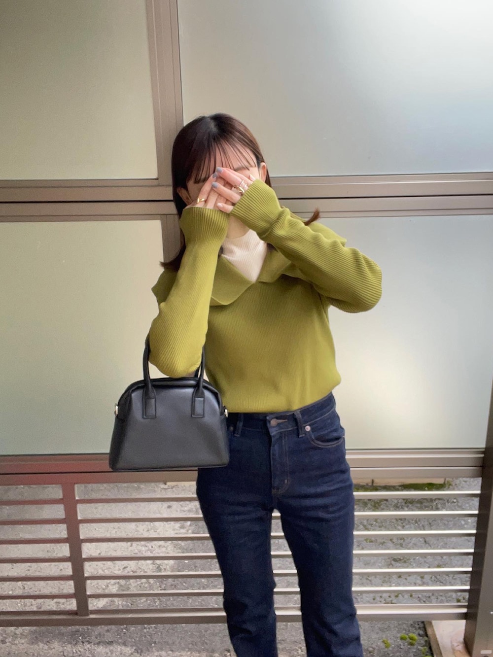 グリーン系のニット/セーター、ホワイト系のニット/セーター、ブルー系のデニムパンツを着用したレディースの冬コーディネートの3枚目の写真