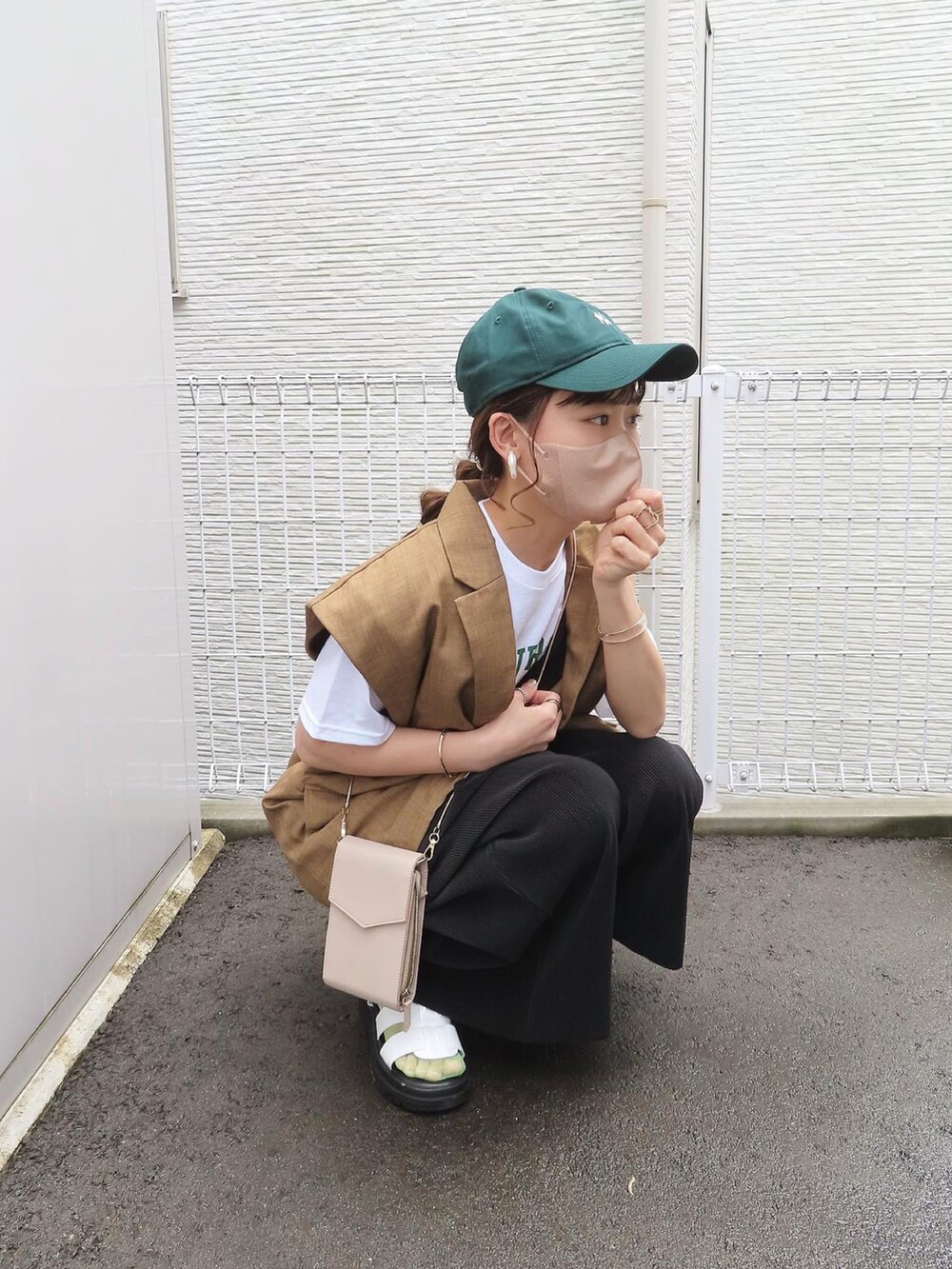 ブラック系のサロペット/オーバーオール、ホワイト系のTシャツ/カットソー、ブラウン系のベストを着用したレディースの夏コーディネートの3枚目の写真